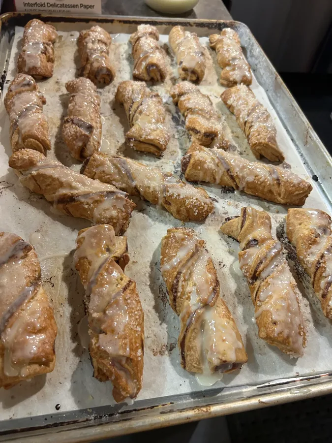 Fresh-baked glazed pastry twists cooling on a tray at Makepeace Farms bakery